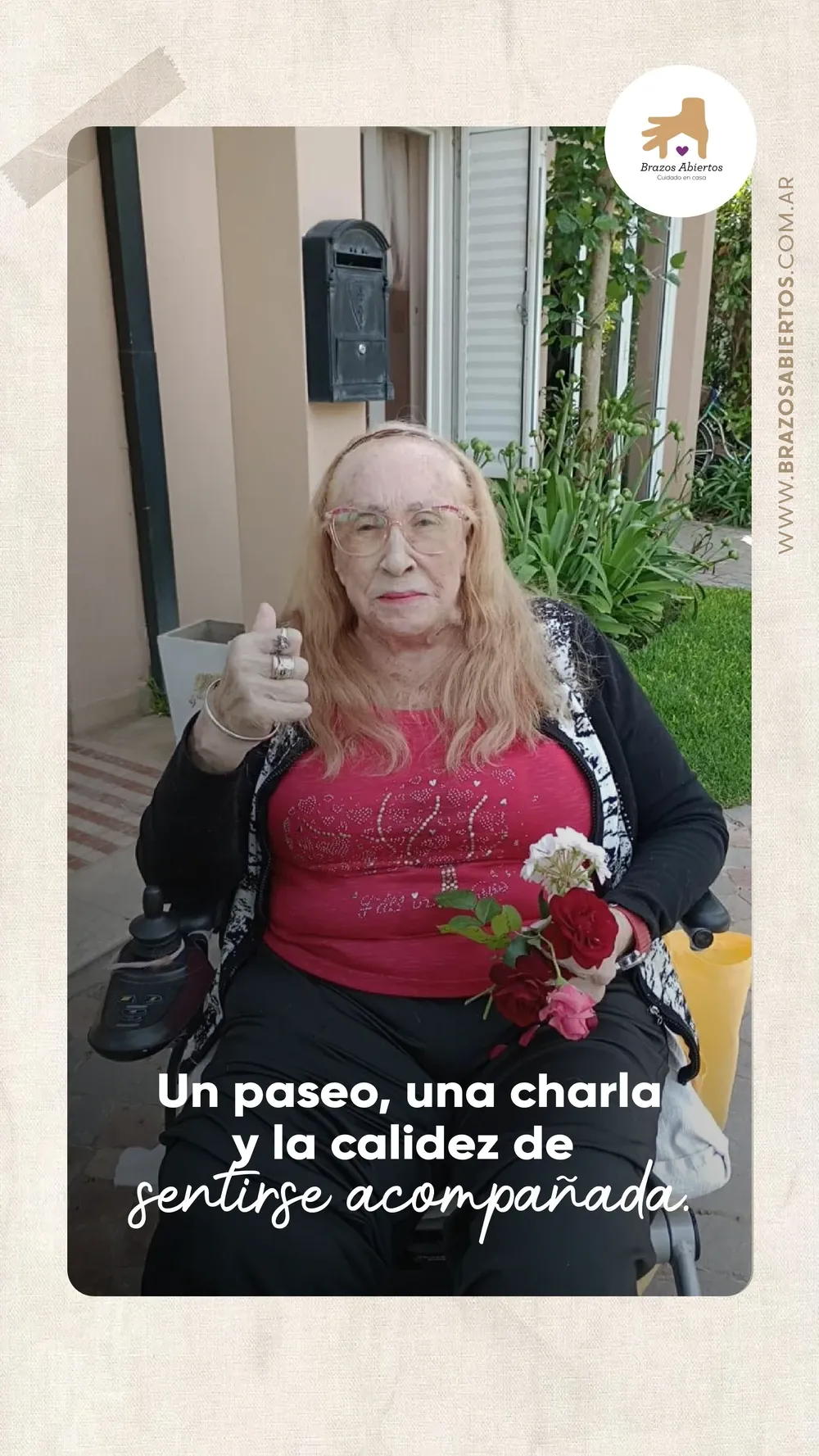 Paciente de Brazos Abiertos durante un paseo en silla de ruedas, con una rosa en la mano