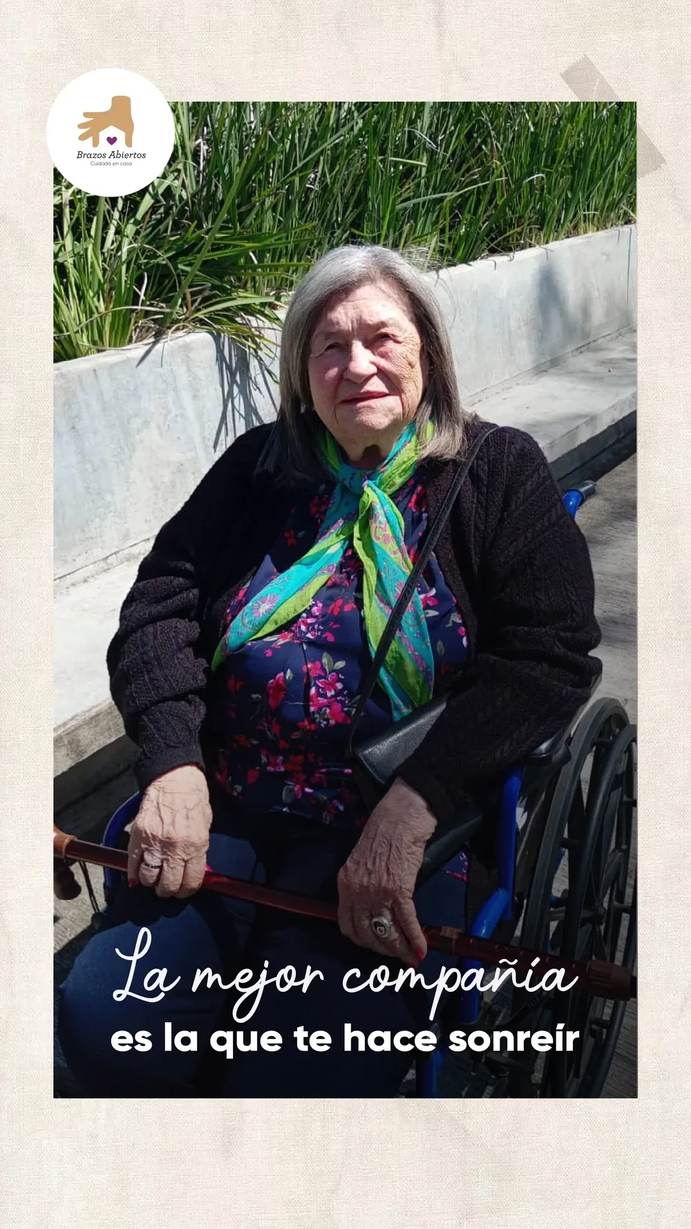 Paciente de Brazos Abiertos sonriendo en su silla de ruedas, con la frase «La mejor compañía es la que te hace sonreír»