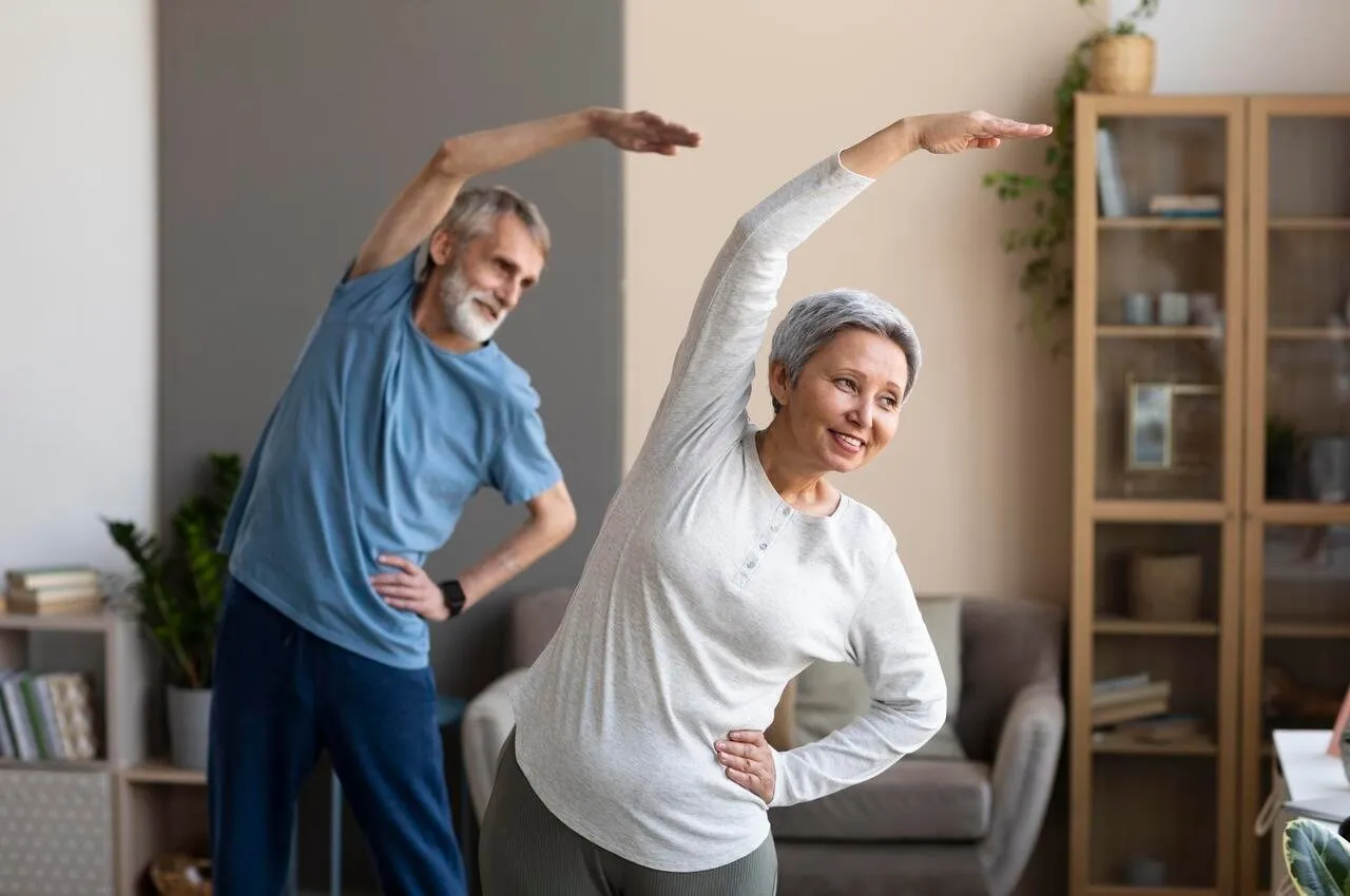 Pareja de adultos mayores haciendo estiramientos en su casa
